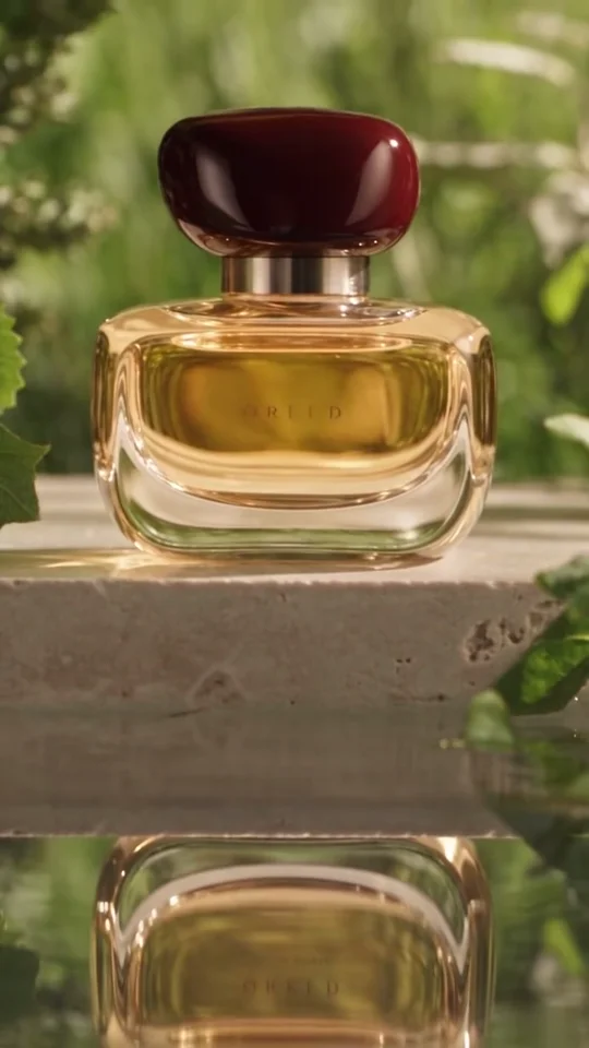 QREED perfume surrounded by green leaves and water reflections